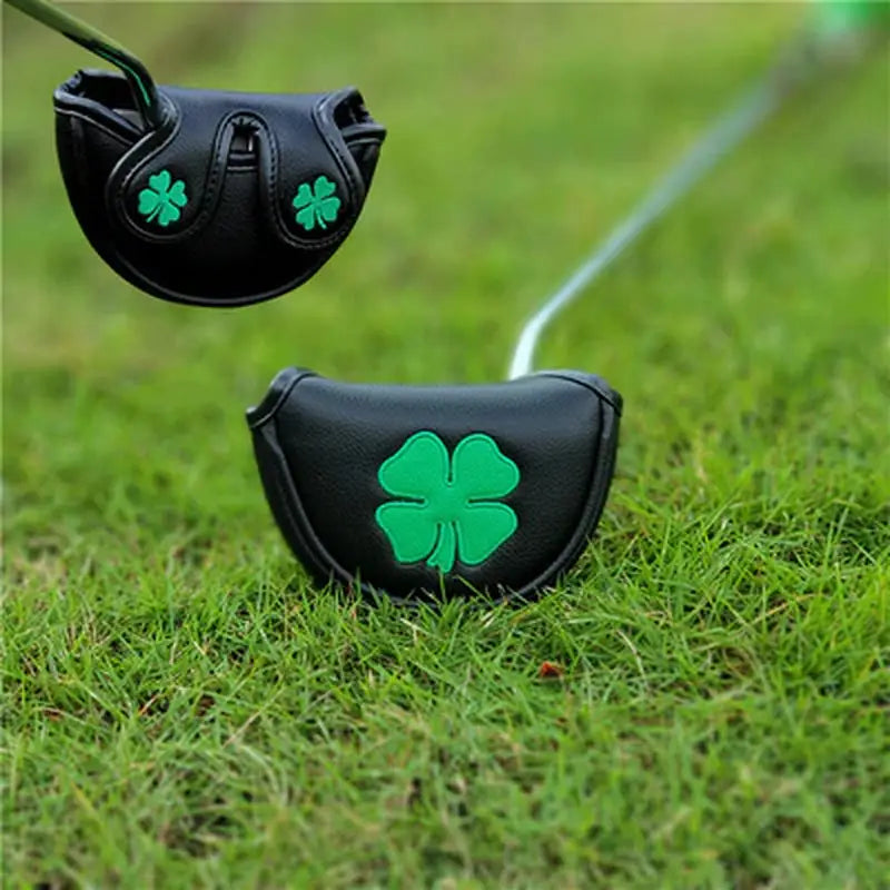 a pair of golf clubs with a green shamrock on the top