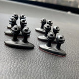 a pair of black metal knobs on a car dashboard