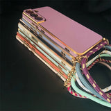 Stack of smartphones with colorful cases and decorative cords attached.