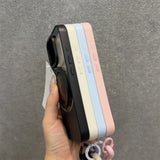 Stacked phone cases in black, white, blue, and pink.