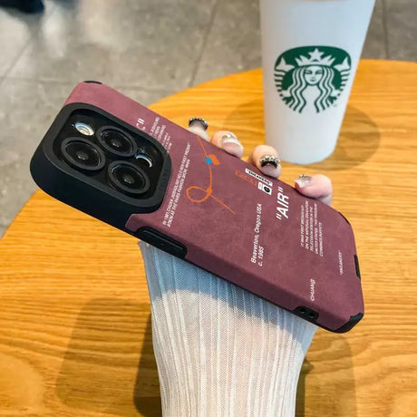 Someone holding a starbucks cup and a phone case on a table