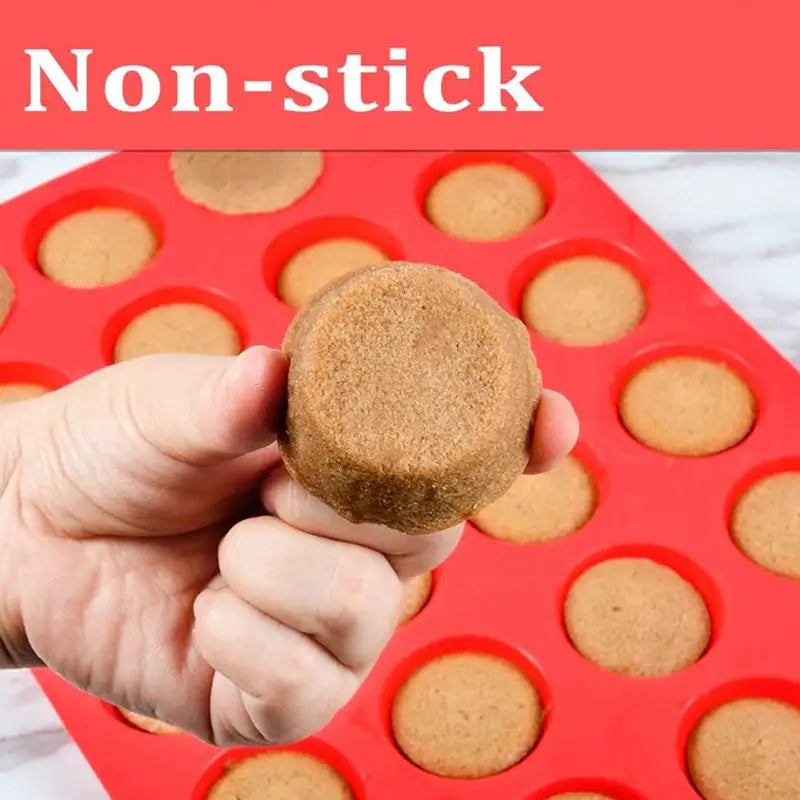 a hand holding a cookie cookie in a red tray