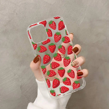 a woman holding a phone case with strawberries on it