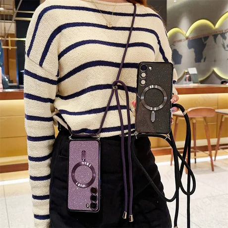 Striped white and navy sweater worn by someone holding two smartphones with ring attachments.