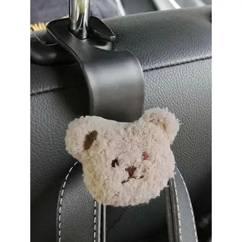 a teddy bear hanging on the back of a car