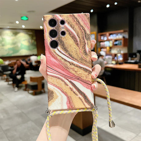 Stylish smartphone case with a marbled pink, gold, and white design and multiple camera cutouts.