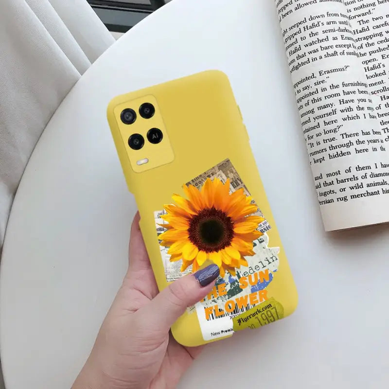 a person holding a yellow phone case with a sunflower on it