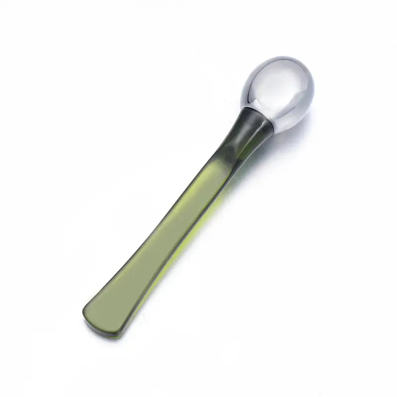 a green spoon with a white handle