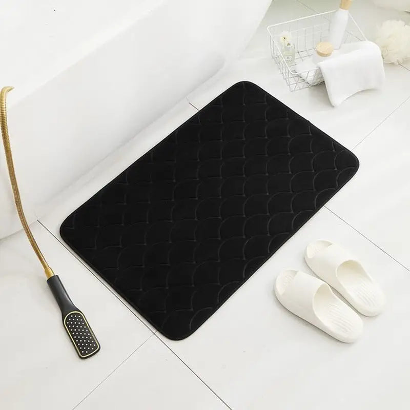 a black bath mat with a gold handle and a black towel