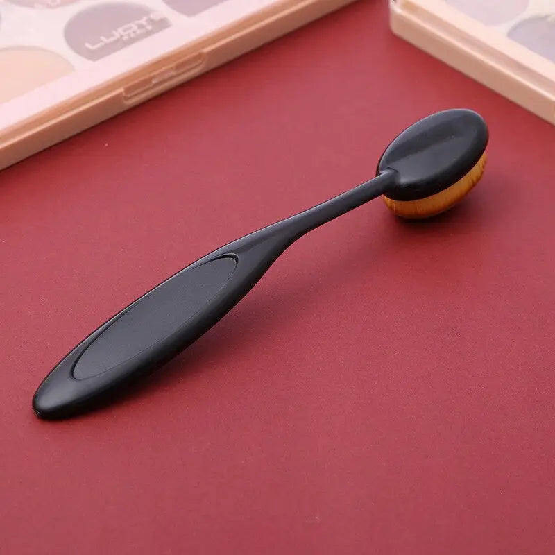 a spoon with a black handle on a red surface