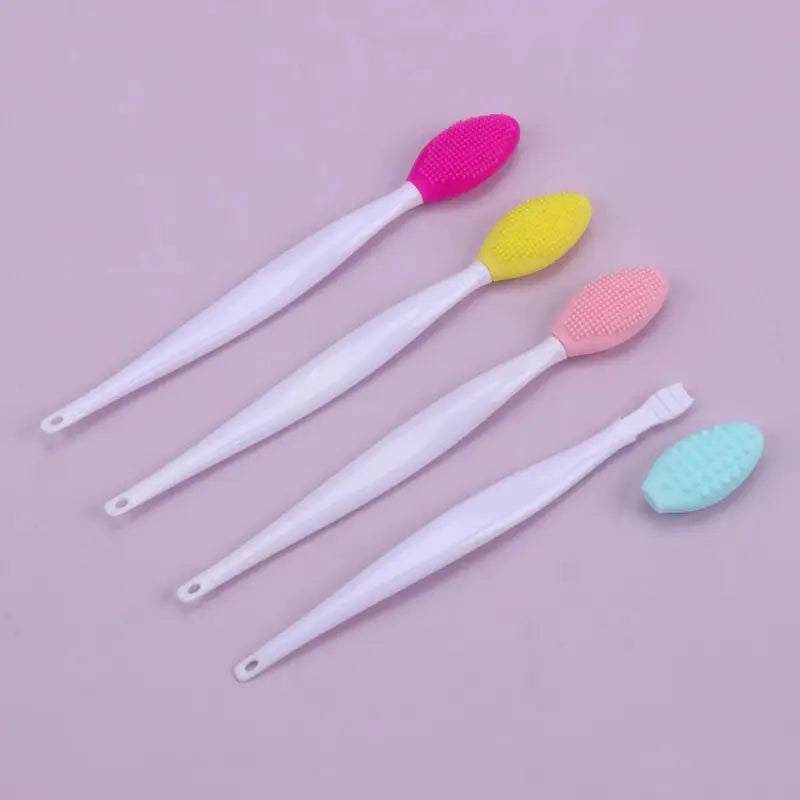 three toothbrushs with different colors on a pink background