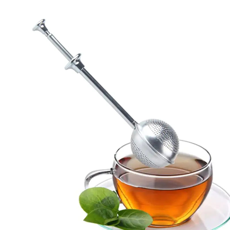 a tea strainer with a cup of tea and a leaf