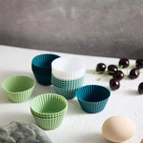 a white table with several different colored cupcakes