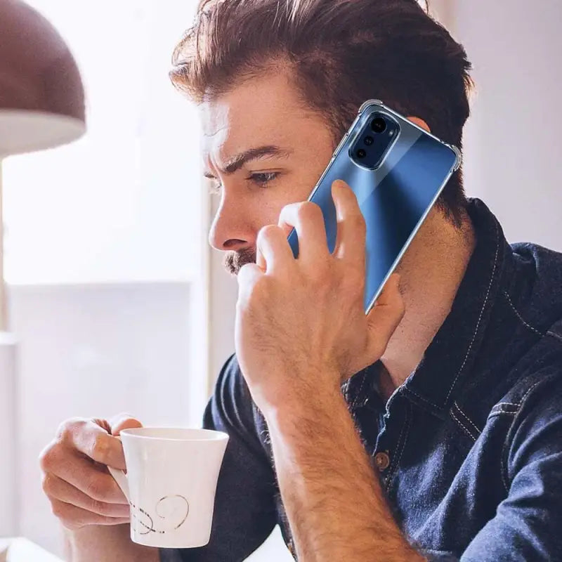a man is talking on his cell while drinking coffee