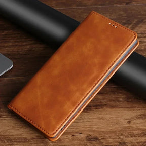 Tan leather wallet or phone case with a folded design on a wooden surface.