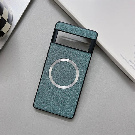 Teal fabric-covered portable battery charger with a circular metallic accent.