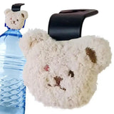 a teddy bear is sitting next to a bottle of water