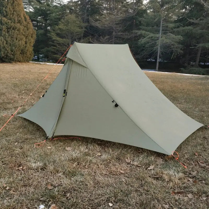 a tent in the grass with a tent attached to it