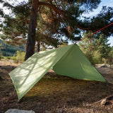 a tent pitched in the shade of a tree