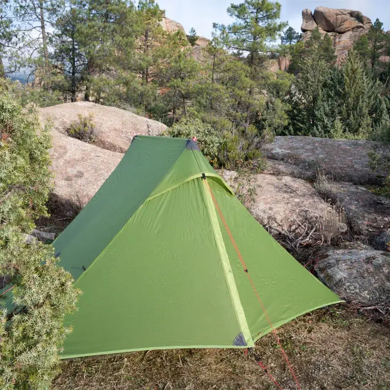 a tent pitched in the shade of a tree