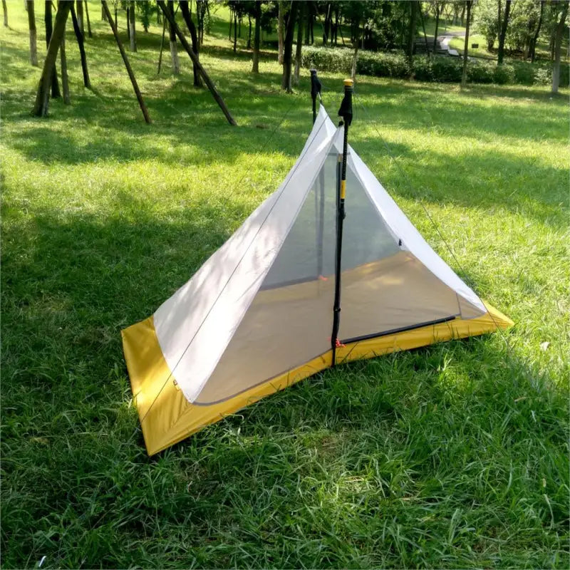 a tent with a yellow and gray tent on the grass