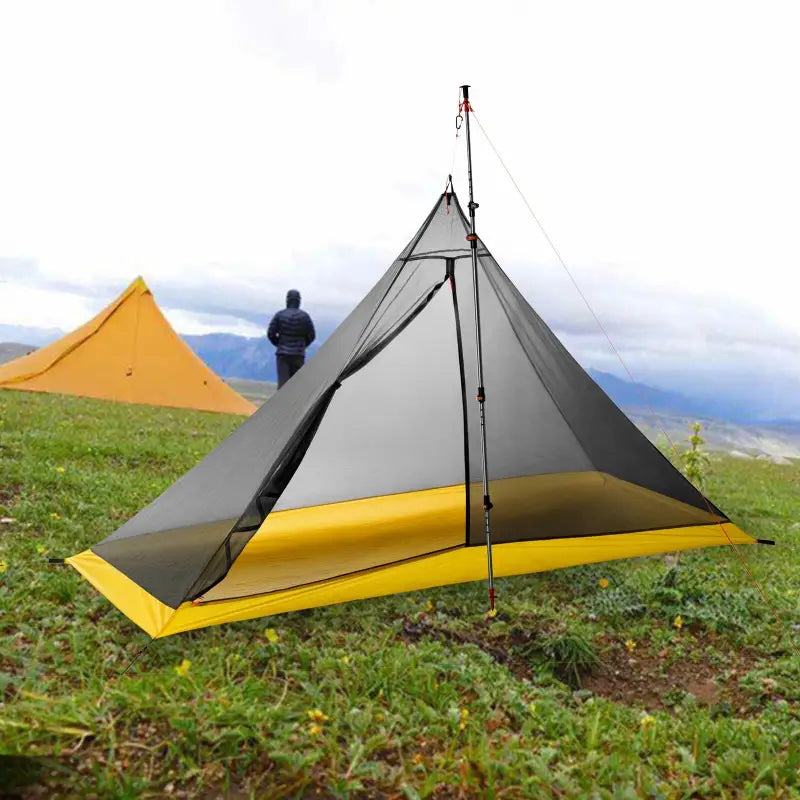 a man is setting up a tent on the grass