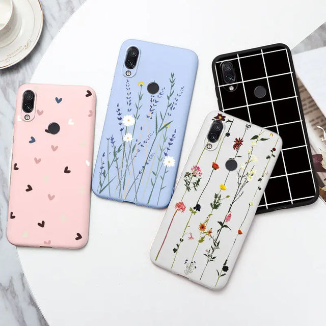 three phone cases with flowers and hearts on them