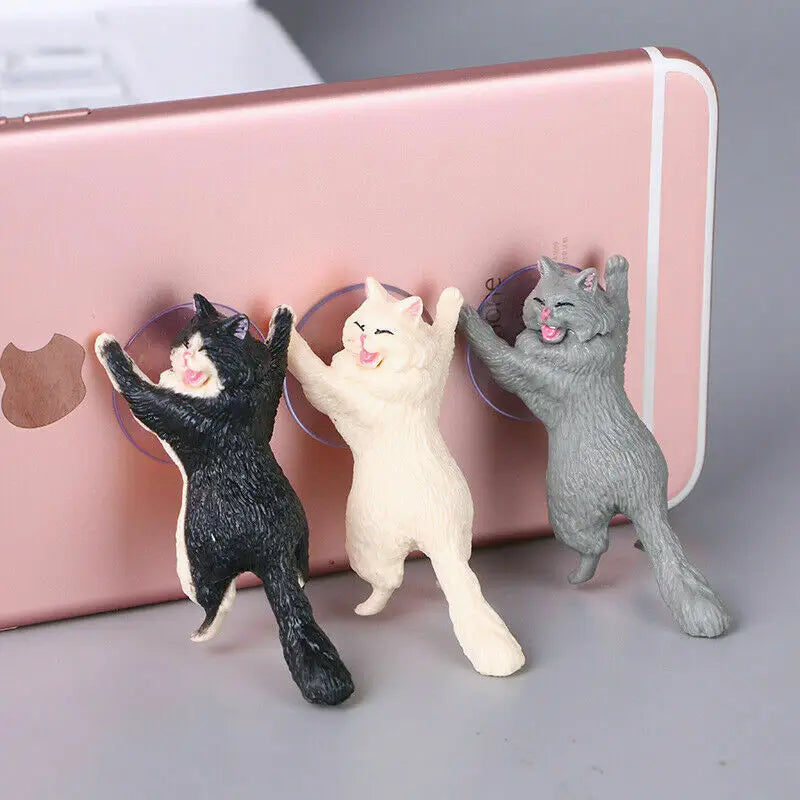 three cats are playing with a phone