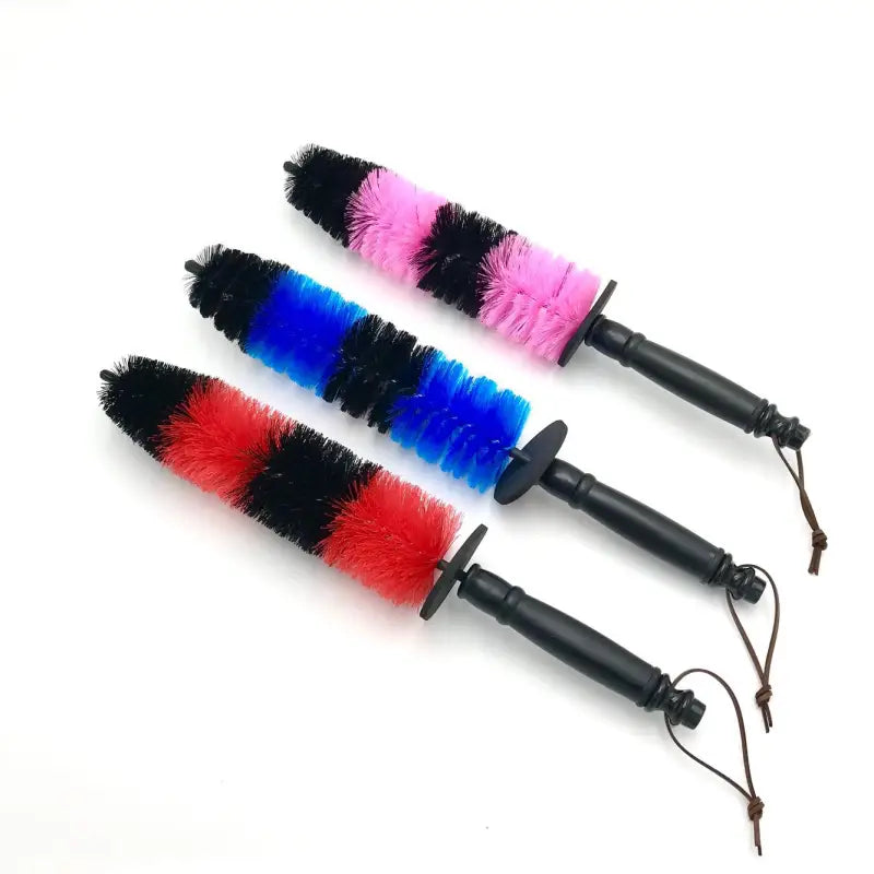 three colorful dusters with a black handle and a red, blue, and pink duster
