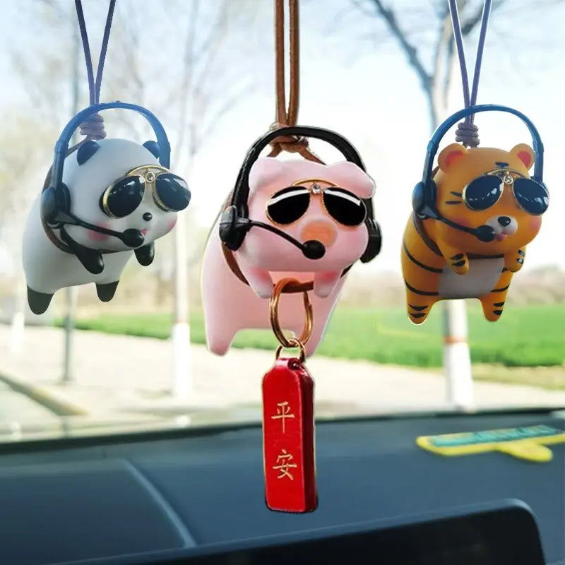 three different colored dog shaped keychais hanging on a car