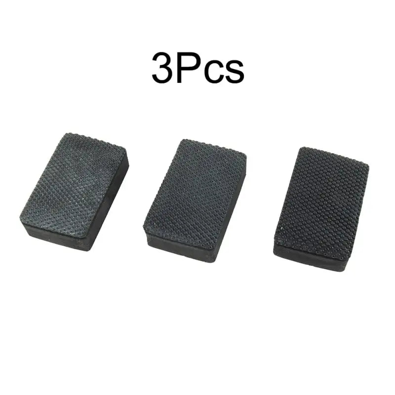 three pieces of black rubber with a white background
