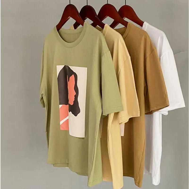 three t - shirts hanging on a rack