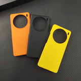 Three smartphone cases in orange, black, and yellow colors with circular cutouts.