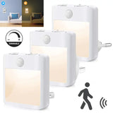 three white motion sensor night lights with a person walking in the background