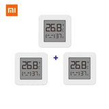 Three white square clocks with thermometers on each side