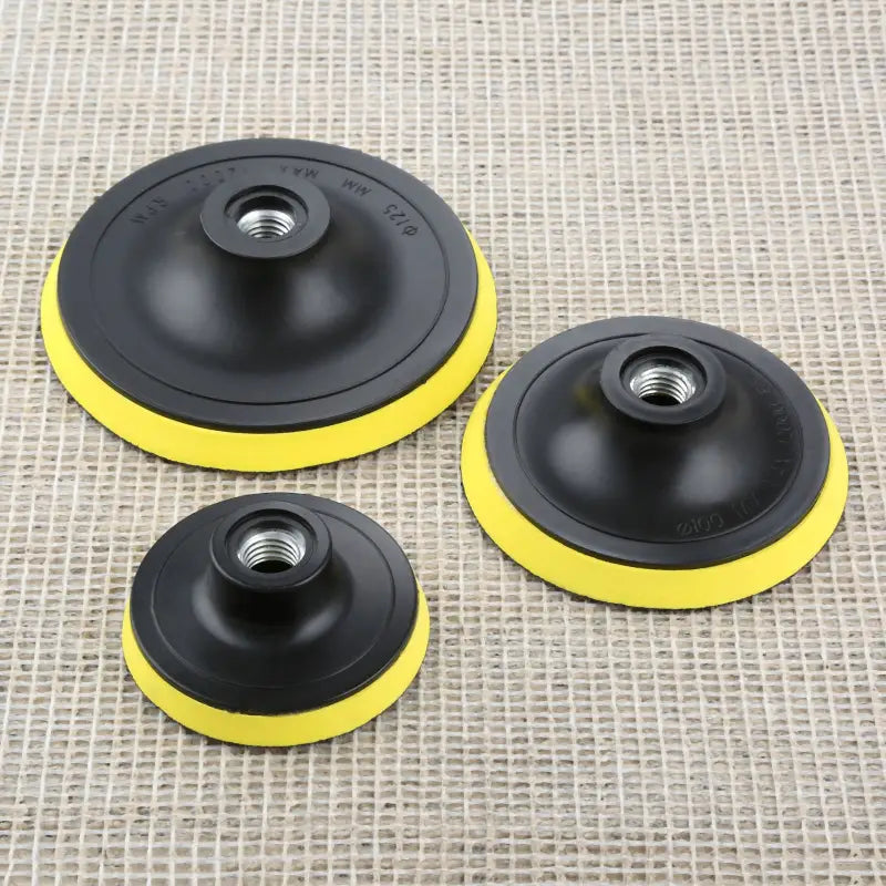 three black and yellow polishers on a beige background