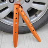 a pair of orange plastic forks on a car wheel