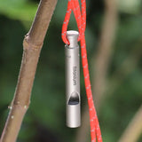 a metal device hanging on a tree branch