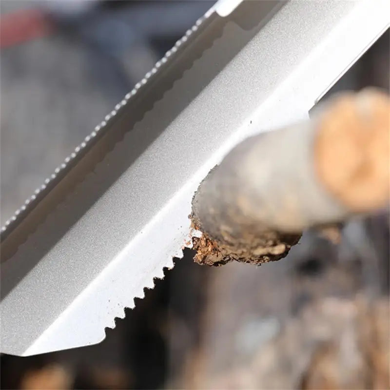 a close up of a knife with a piece of wood in the background