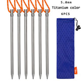 six stainless steel knitting needles with orange handles and a blue bag