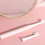 a toothbrush and a mirror on a pink background