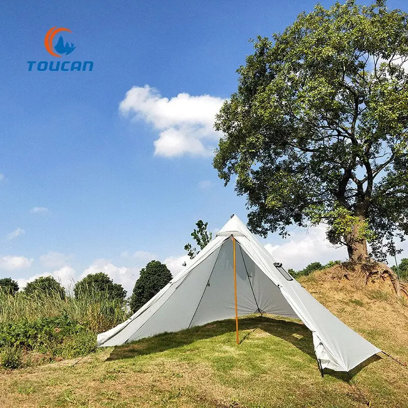 a tent pitched on a hill with a tree in the background