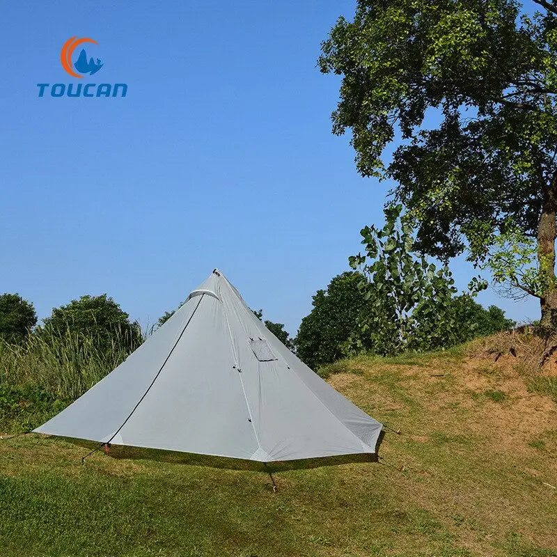 a tent pitched on a hill with a tree in the background