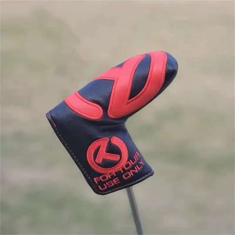a close up of a golf club head cover with a red and black design