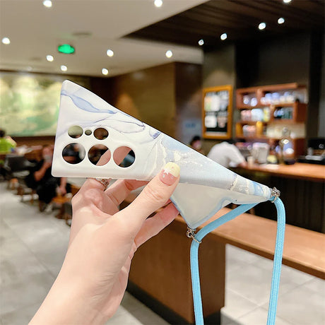 Triangular plastic face mask with holes, held by a hand with painted nails.