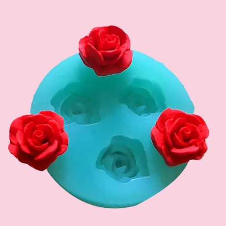 Turquoise silicone mold with three red rose-shaped impressions.