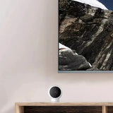 A tv on a wall with a mountain in the background