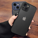 Two black iPhone models with multiple camera lenses held in a hand with dark nail polish.