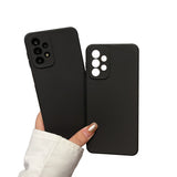 Two black smartphone cases with camera cutouts held in a hand.