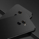 two black smartphones with one facing the camera and one facing the camera
